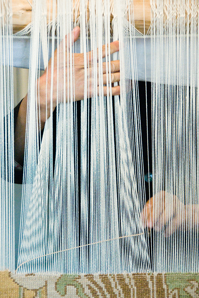 Warp and weft guided by skilled artisans can be seen through the back of this handwoven, fine Persian carpet in the works