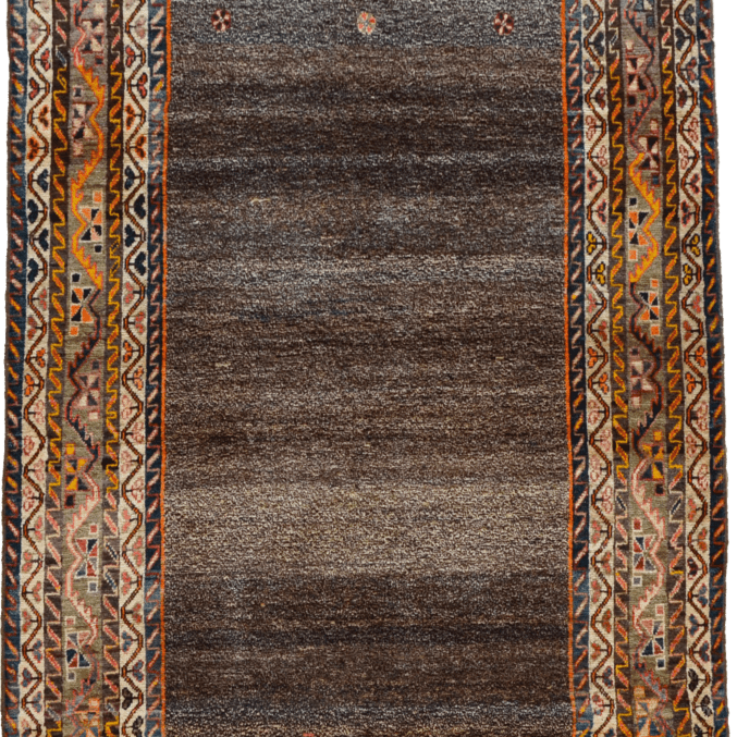This circa 1910 Persian Loristan Gabbeh rug consists of a handspun wool warp, weft and hand knotted pile. The rich colors of the oranges and reds from the vegetable-dyed wool in the border catch the eye, but the field is the real star of this piece. The unique salt and pepper central field of this piece that utilizes mostly undyed wool gives this piece a contemporary feel despite its antique provenance. This rug measures 4'9" x 7'5" and is in excellent vintage condition.